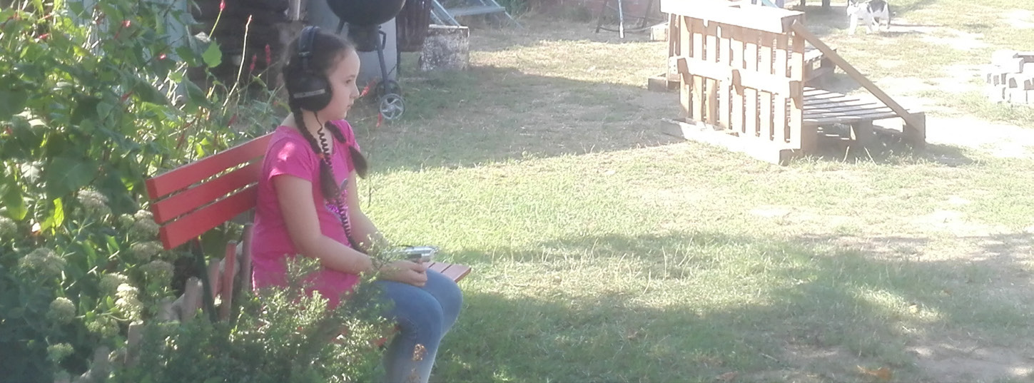 Child listening with headphones during the Fl&uuml;sterwald project